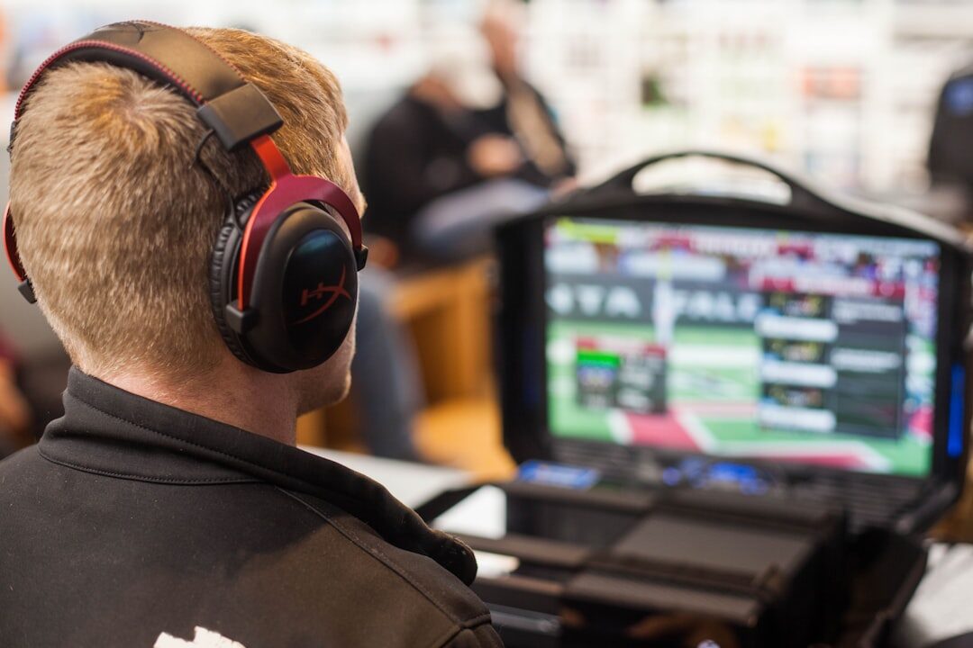 Technical director in a broadcast regie booth watching multiple screens
